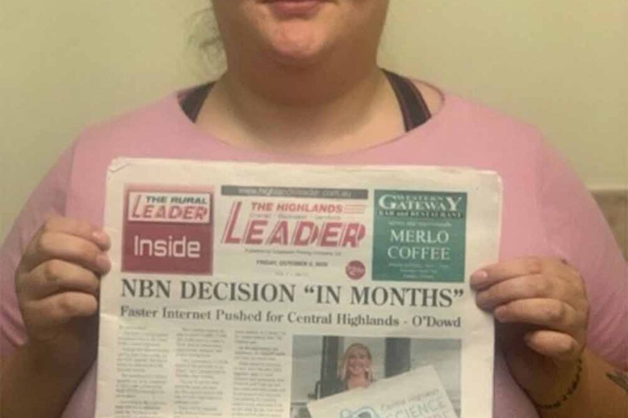 Ali holds up the front page featuring a newspaper article she has co-written