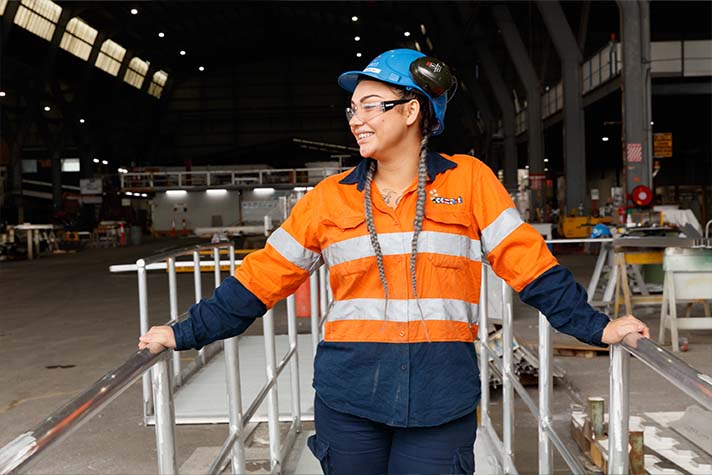 Alex female Incat worker standing on a platform in Hi Vis smiling