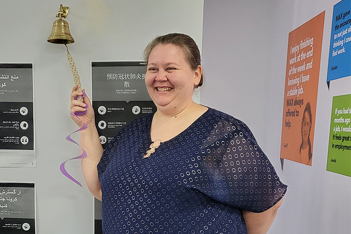 Susan smiles as she "rings the bell" to celebrate getting a job.