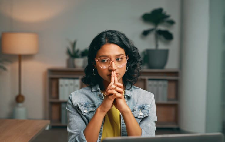 woman sat at her workspace desk with her head in hands wondering what to do next