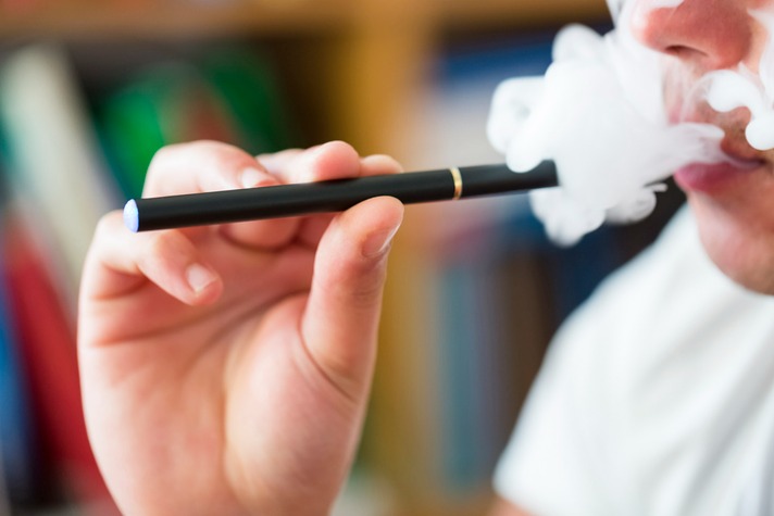 Danger of Vaping - Young adult smoking from a vape