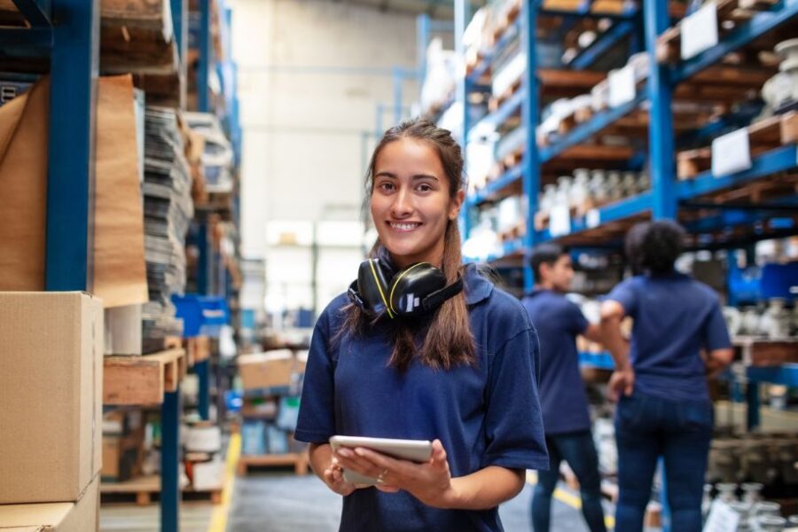 Woman warehouse worker with people in background