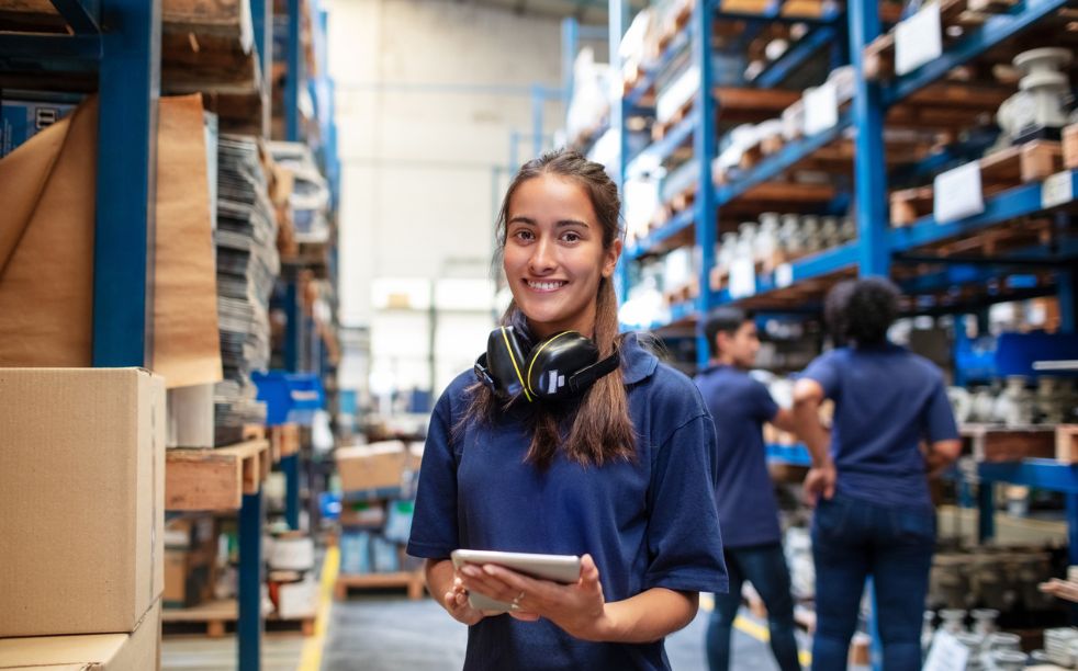 Woman warehouse worker with people in background