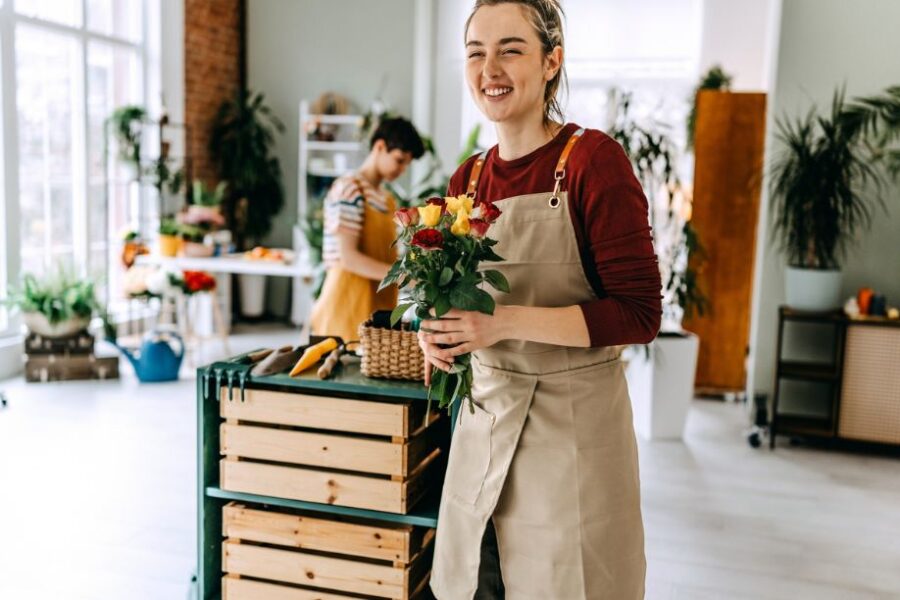 young female happy working in a flower shop