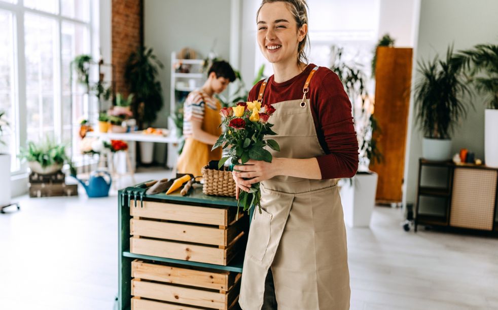 young female happy working in a flower shop