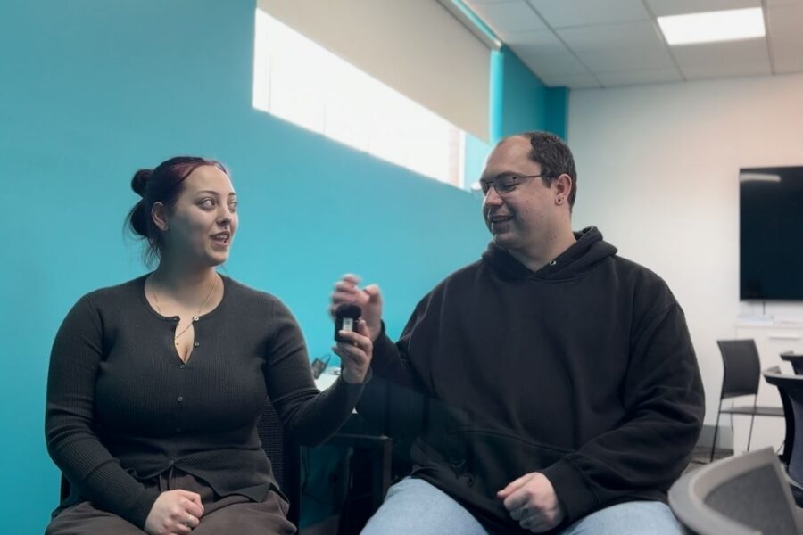 Kat and Rob, Employability Skills Training participants, smiling and conversing in a classroom.
